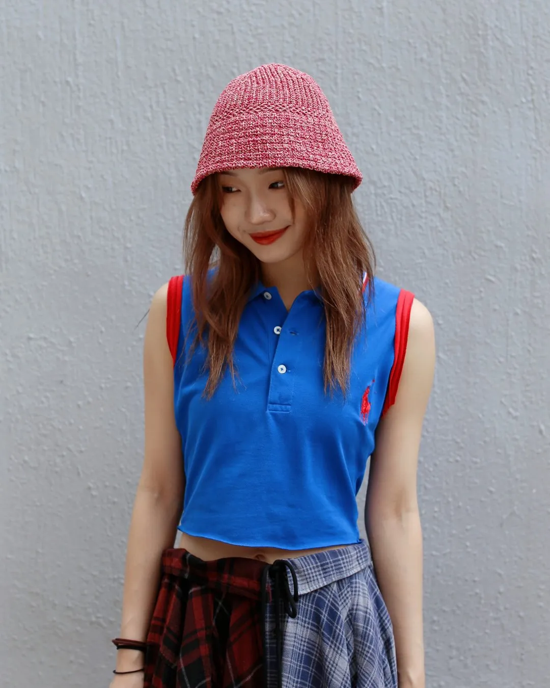 Reworked blue polo vest with a red knit hat and patchwork skirt